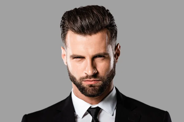 Portrait of angry handsome businessman in black suit isolated on grey — Stock Photo