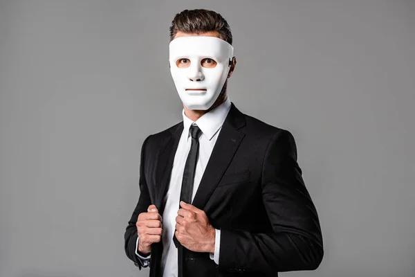 Businessman in black suit and white mask isolated on grey — Stock Photo