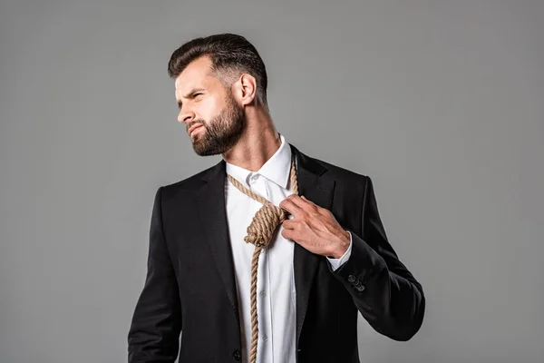 Schöner Geschäftsmann im schwarzen Anzug mit Schlinge um den Hals isoliert auf grau — Stockfoto