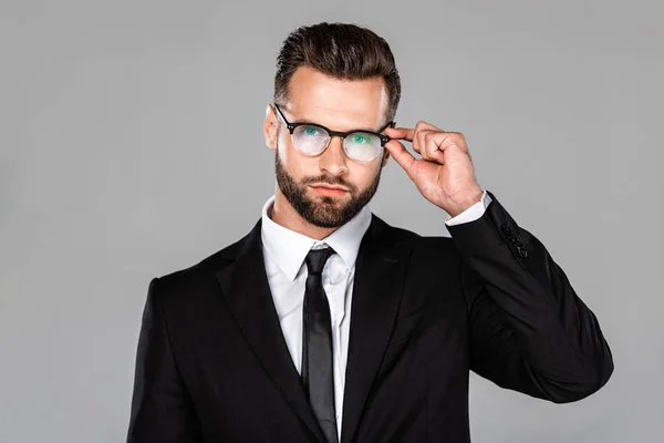 Handsome businessman in black suit and glasses isolated on grey — Stock Photo