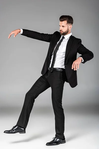 Full length view of creepy zombie businessman in black suit on grey — Stock Photo