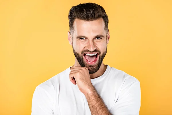 Emocionado hombre guapo feliz en camiseta blanca aislado en amarillo - foto de stock