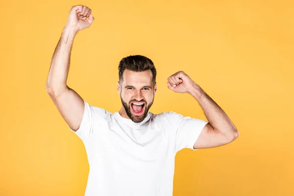 Happy handsome man in white t-shirt showing yes gesture isolated on yellow — Stock Photo