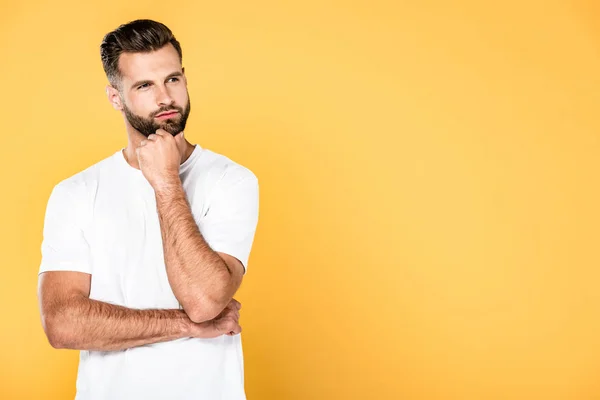 Bel homme réfléchi en t-shirt blanc isolé sur jaune avec espace de copie — Photo de stock