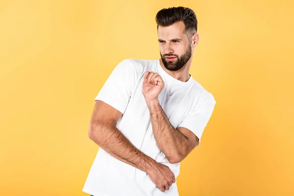 Hombre guapo en camiseta blanca bailando aislado en amarillo - foto de stock