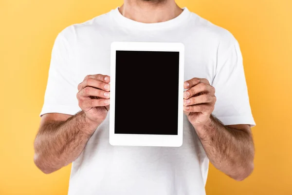 Vista recortada del hombre en camiseta blanca que muestra tableta digital con pantalla en blanco aislado en amarillo - foto de stock