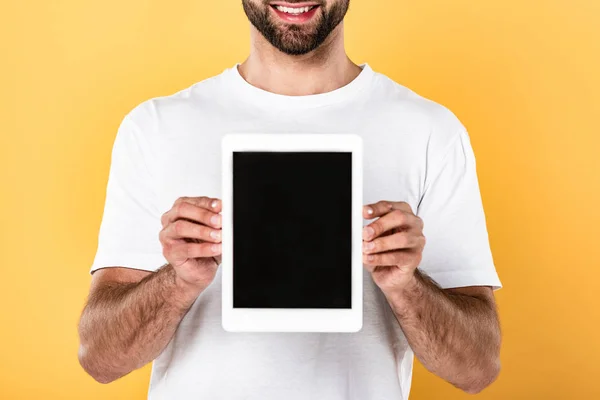 Teilaufnahme eines lächelnden Mannes im weißen T-Shirt, der ein digitales Tablet mit leerem Bildschirm zeigt, isoliert auf gelb — Stockfoto