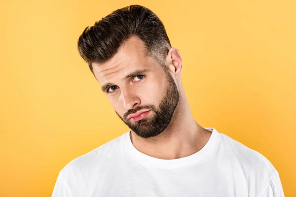 Upset handsome man in white t-shirt isolated on yellow — Stock Photo