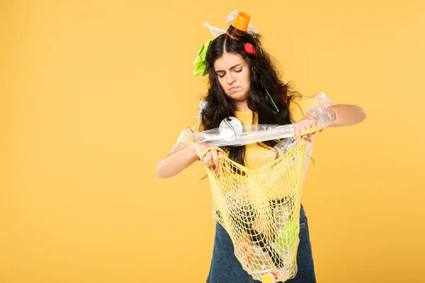 Trauriges Mädchen mit Müll im Haar, Tasche mit Müll auf gelb isoliert — Stockfoto