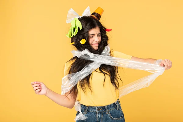 Confus jeune femme avec des déchets dans les cheveux isolés sur jaune — Photo de stock