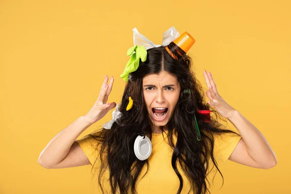 Shocked girl shouting with rubbish in hair isolated on yellow — Stock Photo