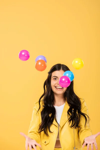 Menina bonita feliz com bolas coloridas, isolado no amarelo — Fotografia de Stock
