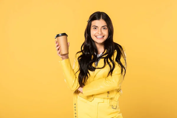 Hermosa chica sonriente con café para ir aislado en amarillo - foto de stock