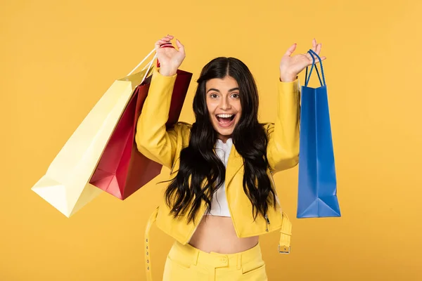 Mulher bonita animado com sacos de compras, isolado em amarelo — Fotografia de Stock