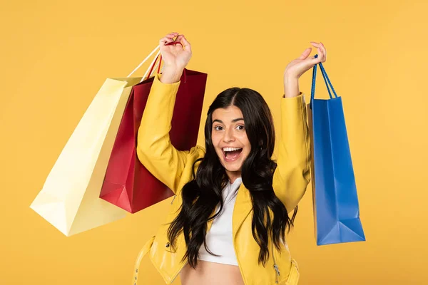 Fille excitée avec des sacs à provisions, isolé sur jaune — Photo de stock