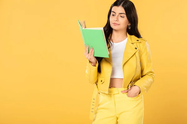 Sorridente bruna ragazza lettura libro, isolato su giallo — Foto stock