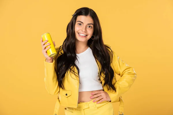 Bela morena menina segurando lata de refrigerante, isolado no amarelo — Fotografia de Stock