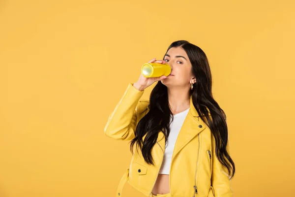 Attractive woman drinking soda from can, isolated on yellow — Stock Photo