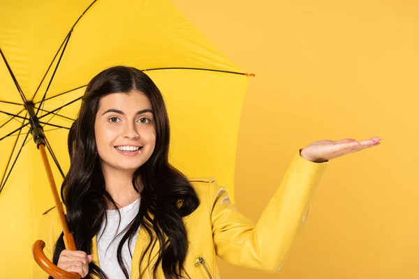 Belle fille posant avec parapluie, isolé sur jaune — Photo de stock