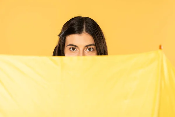 Pretty girl posing with umbrella, isolated on yellow — Stock Photo