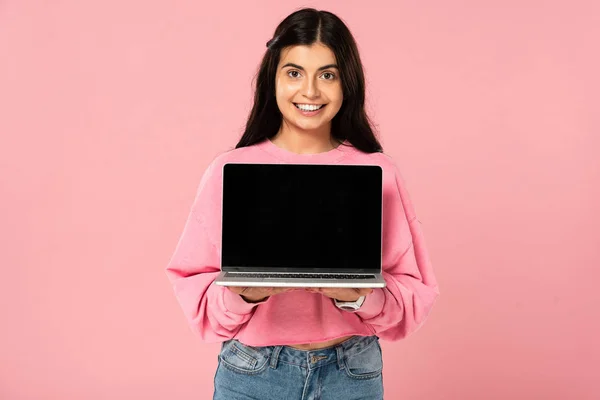 Belle fille montrant ordinateur portable avec écran blanc, isolé sur rose — Photo de stock