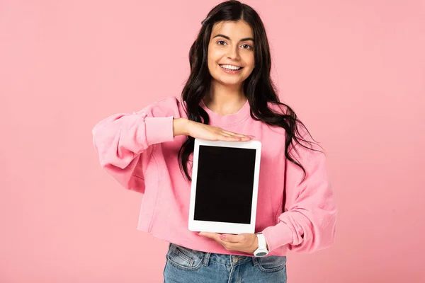 Hermosa mujer que presenta tableta digital con pantalla en blanco, aislado en rosa - foto de stock
