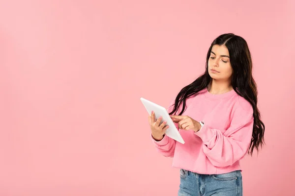 Beautiful serious woman using digital tablet, isolated on pink — Stock Photo
