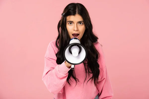 Brunette girl screaming into megaphone, isolated on pink — Stock Photo