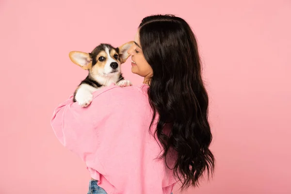 Mujer sonriente sosteniendo lindo cachorro, aislado en rosa - foto de stock