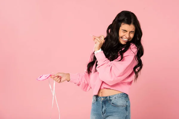 Смешная девушка держит иглу и розовый шарик, изолированный на розовый — стоковое фото