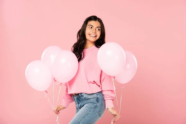 Красивая счастливая девушка с розовыми воздушными шарами, изолированная на розовом — стоковое фото