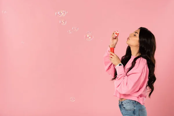 Belle fille soufflant bulles de savon isolé sur rose — Photo de stock