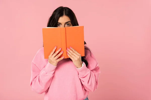Brunette fille tenant livre, isolé sur rose — Photo de stock