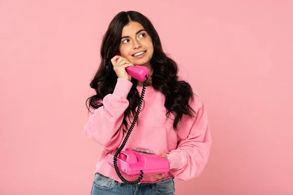 Attractive girl talking on retro telephone isolated on pink — Stock Photo