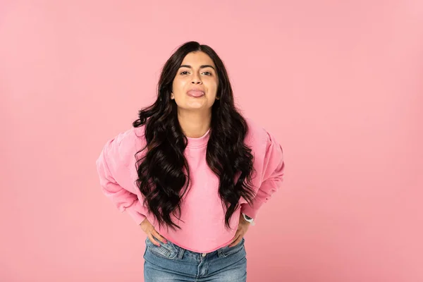 Attraktives Mädchen streckt die Zunge isoliert auf rosa — Stockfoto