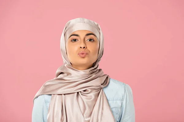 Attractive muslim girl in hijab kissing isolated on pink — Stock Photo