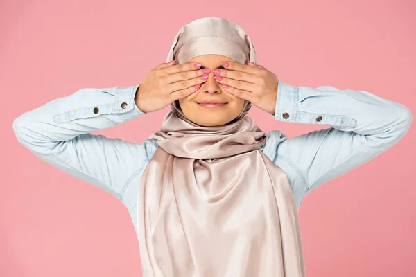 Smiling muslim girl in hijab closing eyes, isolated on pink — Stock Photo