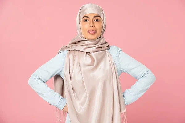 Belle femme musulmane drôle en hijab langue collante dehors, isolé sur rose — Photo de stock