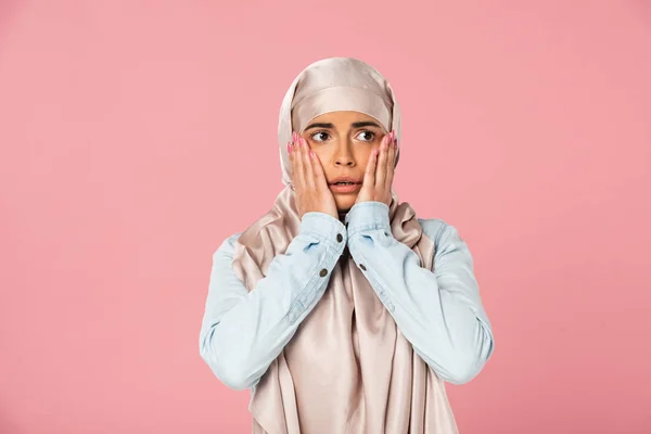 Испуганная арабская женщина в хиджабе жестикулирует, изолированная на розовом — стоковое фото