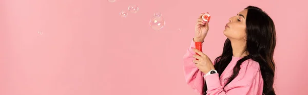 Funny girl blowing soap bubbles isolated on pink — Stock Photo