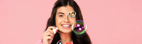 Cheerful young woman blowing soap bubbles isolated on pink — Stock Photo