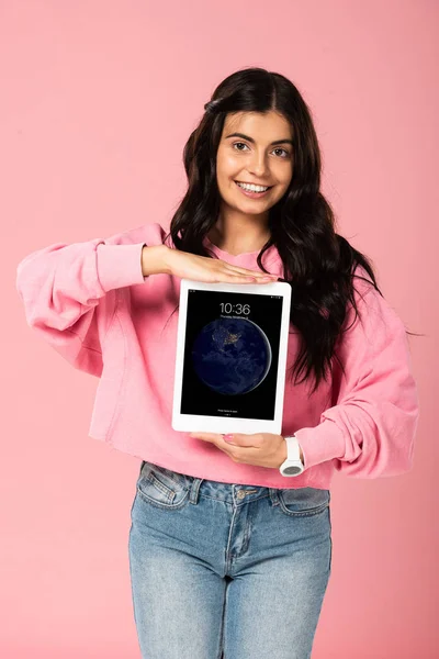 KYIV, UCRÂNIA - JULHO 30, 2019: menina sorridente segurando ipad tablet, isolado em rosa — Fotografia de Stock