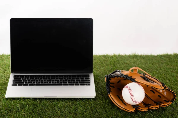 Baseballhandschuh und Ball in der Nähe von Laptop mit leerem Bildschirm auf grünem Gras isoliert auf weißem, Sportwetten-Konzept — Stockfoto