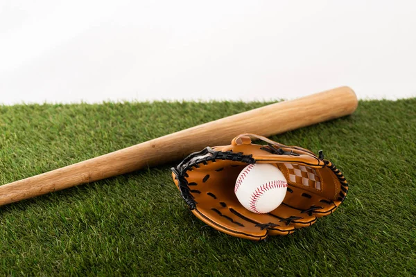 Baseball bat, glove and ball on green grass isolated on white, sports betting concept — Stock Photo