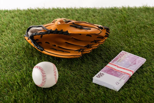 Baseballhandschuh und Ball in der Nähe von Euro-Banknoten auf grünem Gras isoliert auf weißem, Sportwetten-Konzept — Stockfoto