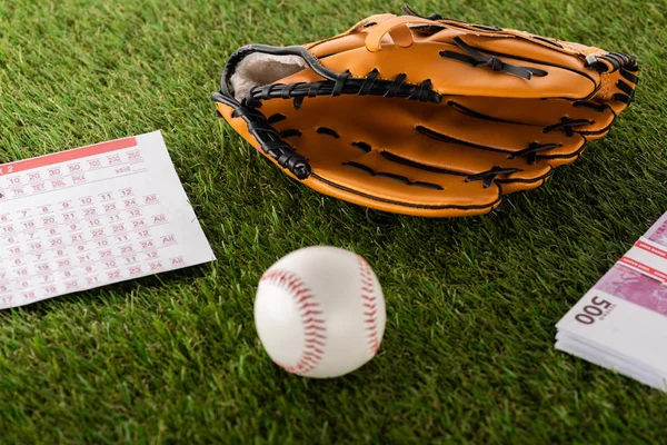 Luva de basebol e bola perto de notas de euro e lista de apostas em relva verde isolada em branco, conceito de apostas desportivas — Fotografia de Stock