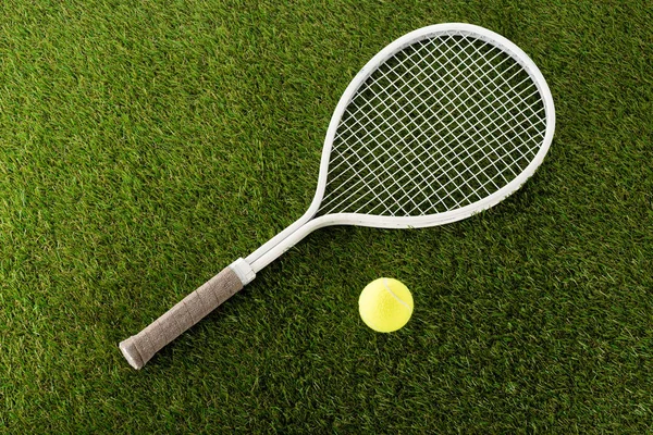 Vue de dessus de raquette de tennis et balle sur herbe verte, concept de paris sportifs — Photo de stock