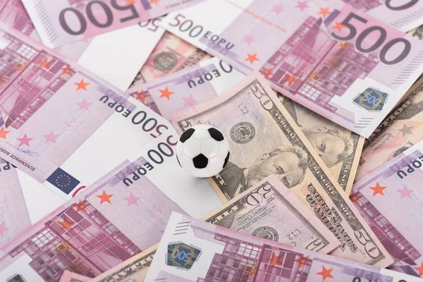 Вид зверху на іграшковий футбольний м'яч на банкнотах євро і долара, концепція спортивних ставок — стокове фото