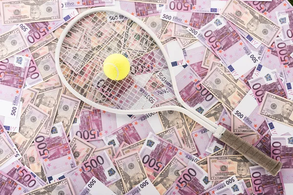 Vista superior de la raqueta de tenis y pelota en euros y billetes de dólar, concepto de apuestas deportivas - foto de stock