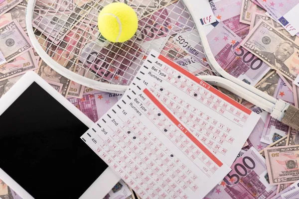 Draufsicht auf digitales Tablet, Wettlisten, Tennisschläger und Ball auf Euro- und Dollar-Banknoten, Sportwetten-Konzept — Stockfoto